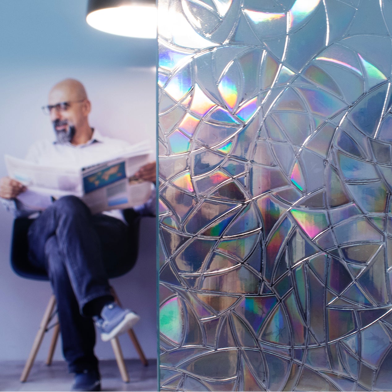 Anwendungsbild Dekorfolie CDFS 6024 Prisma, Adhäsionsfolie, Innenverlegung, statisch haftend, Personen hinter Folie, schneller Sichtschutz, dekorativ, strukturierte Folienoberfläche, kurz- und mittelfristige Anwendung