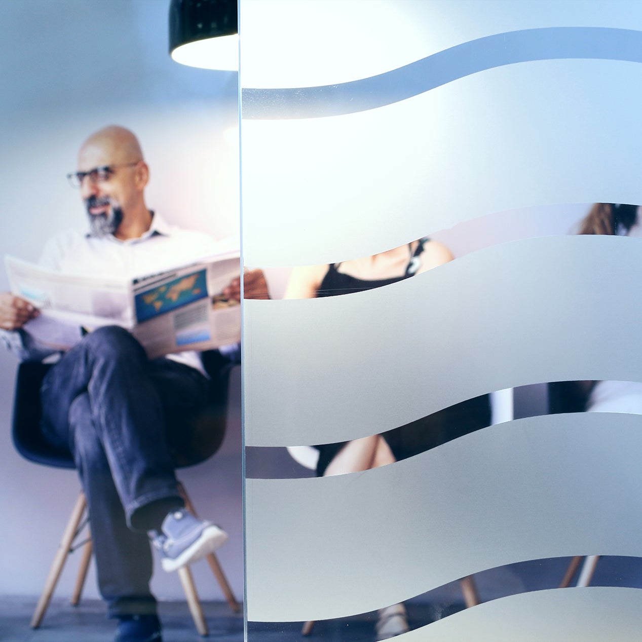 Anwendungsbild Dekorfolie CDF 2450 Wellen, Innenverlegung, Personen hinter Folie, gewellte Streifen in Sandstrahloptik 45mm hoch, Abstand 10mm, Sichtschutz