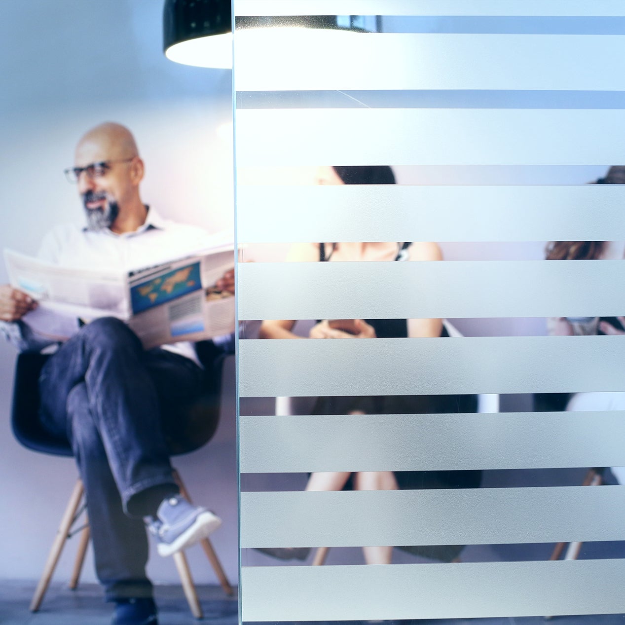 Anwendungsbild Dekorfolie CDF 2404 Streifen, Innenverlegung, Personen hinter Folie, Streifen in Sandstrahloptik 13mm, Abstand 6mm, Sichtschutz