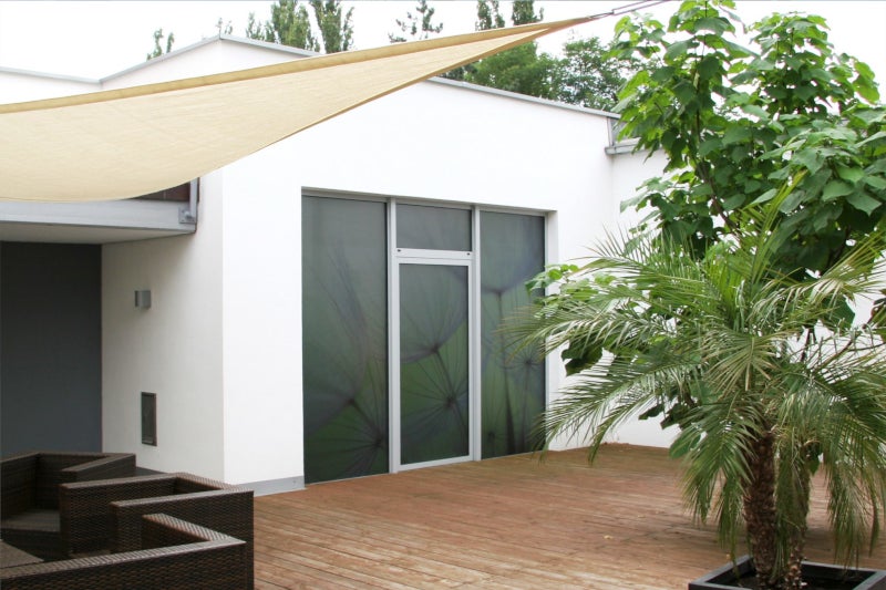 Außenansicht auf eine Glasfront/Balkontür mit bedruckter Dekorfolie (Pusteblumen)