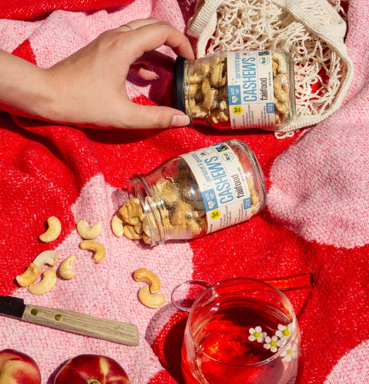 Glaeser mit gesalzenen Cashews auf bunter Picknickdecke