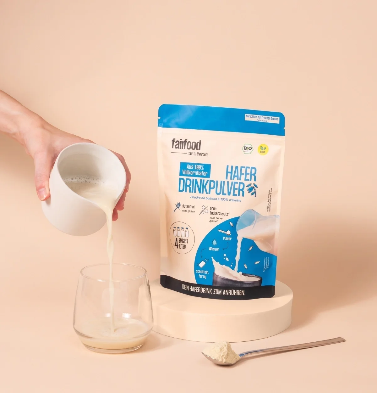 Haferdrink wird in Glas gegossen mit Pulver im Beutel daneben