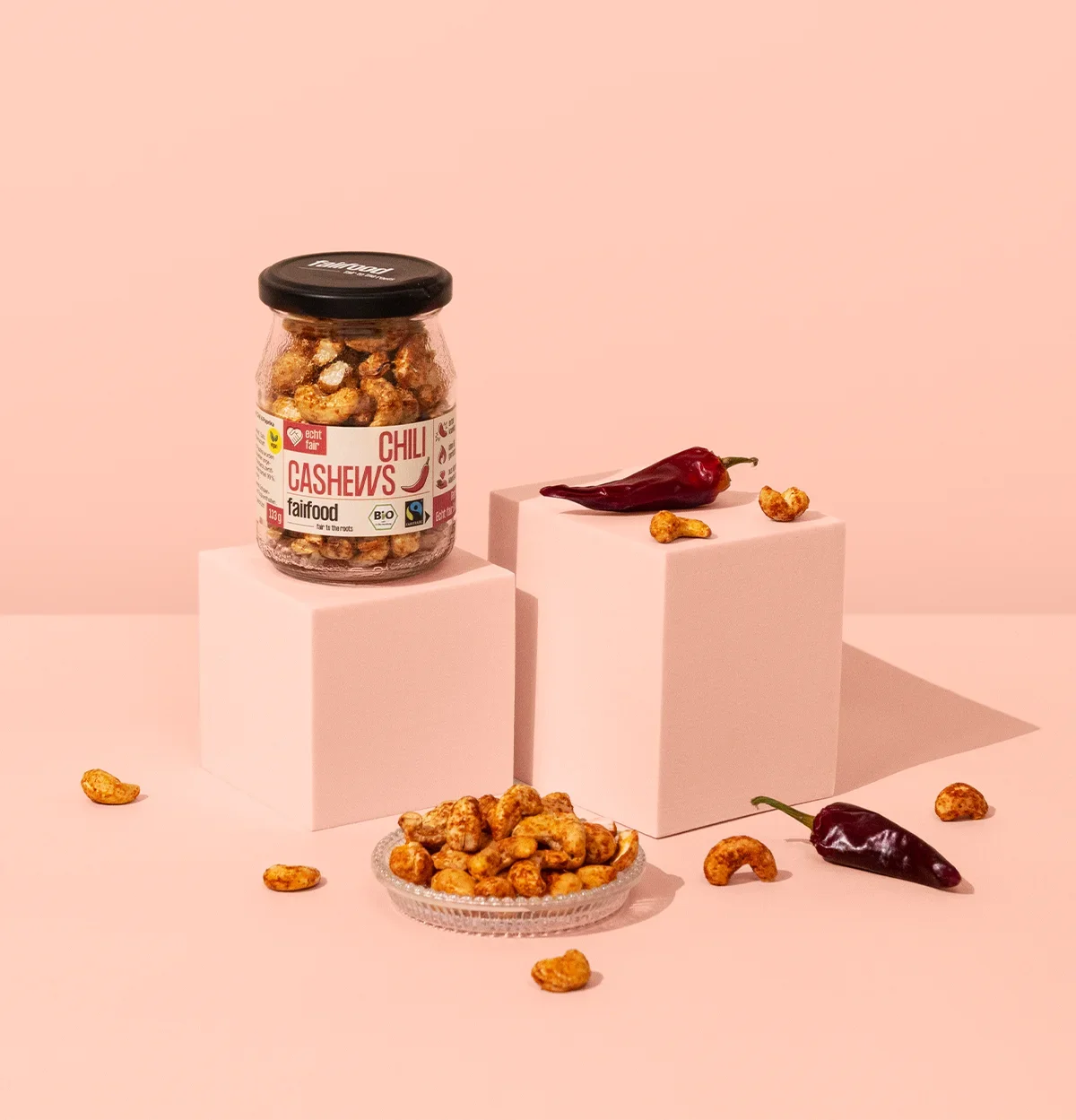 Glas Chili Cashews vor rotem Hintergrund