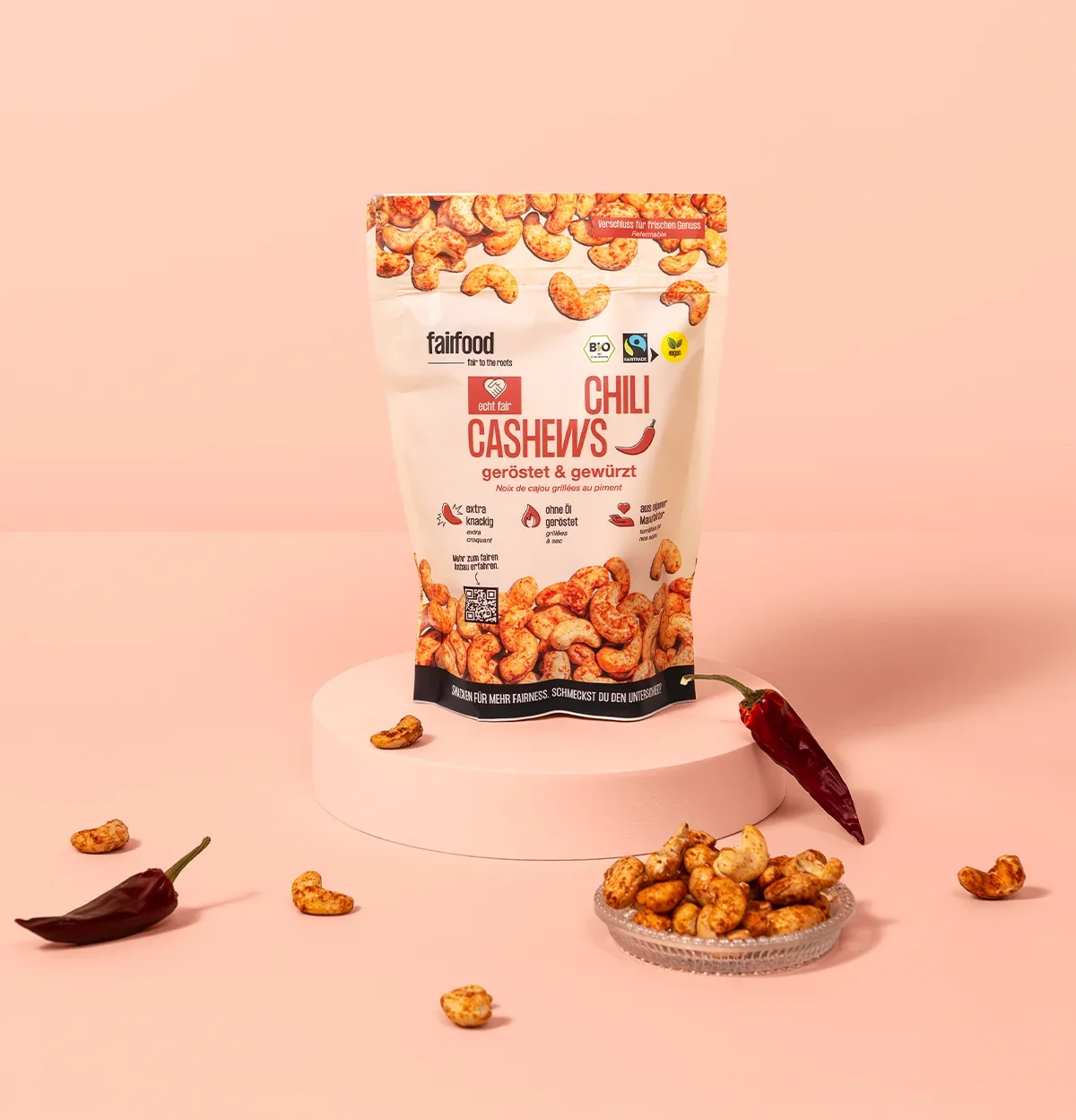 Beutel Chili Cashews vor rotem Hintergrund