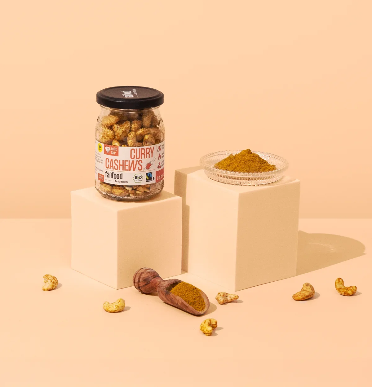 Glas Curry Cashews vor orangenem Hintergrund