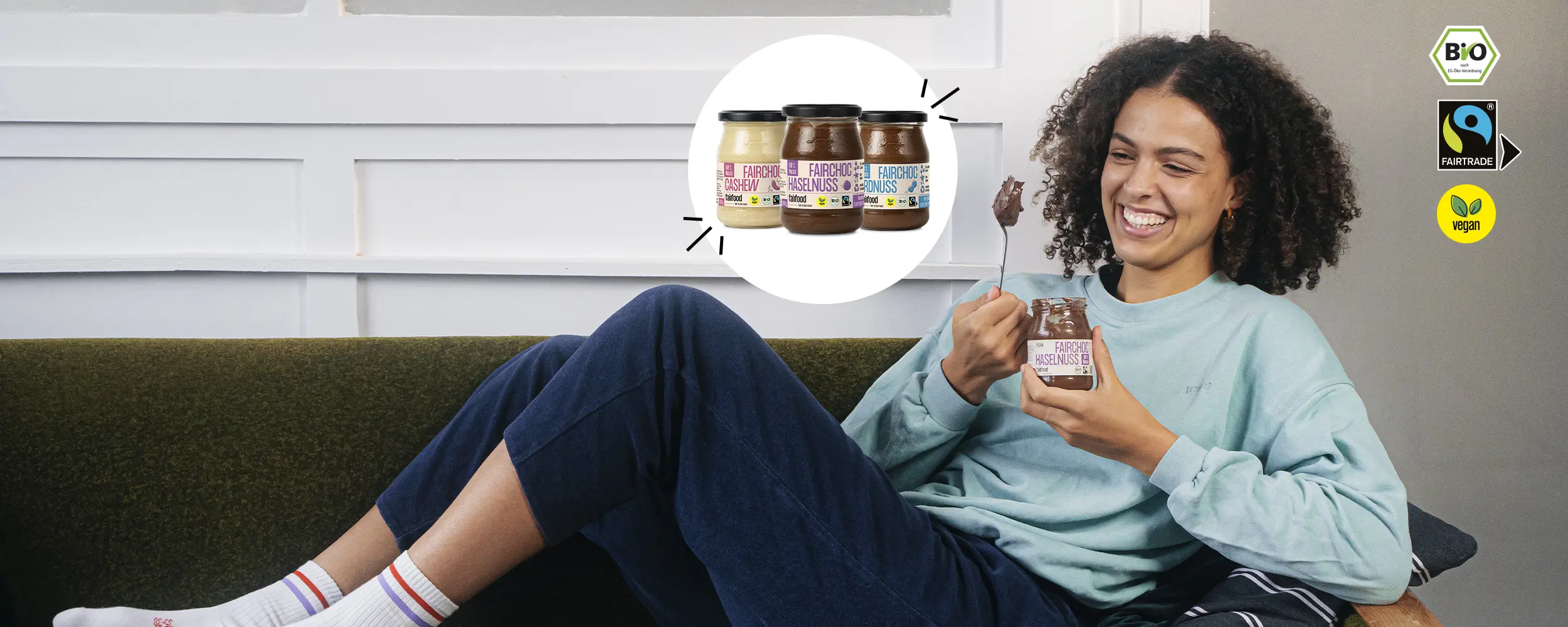 Person liegt auf einem Sofa mit einem Pfandglas fairfood Schokocreme und einem Löffel in der Hand, daneben Abbildung von den 3 Sorten fairfood Schokocreme