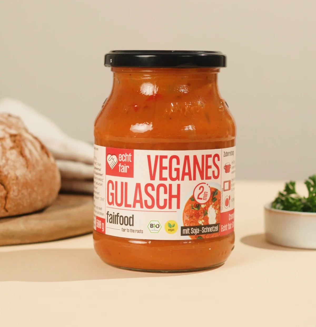 gulasch im glas neben brot und kraeutern