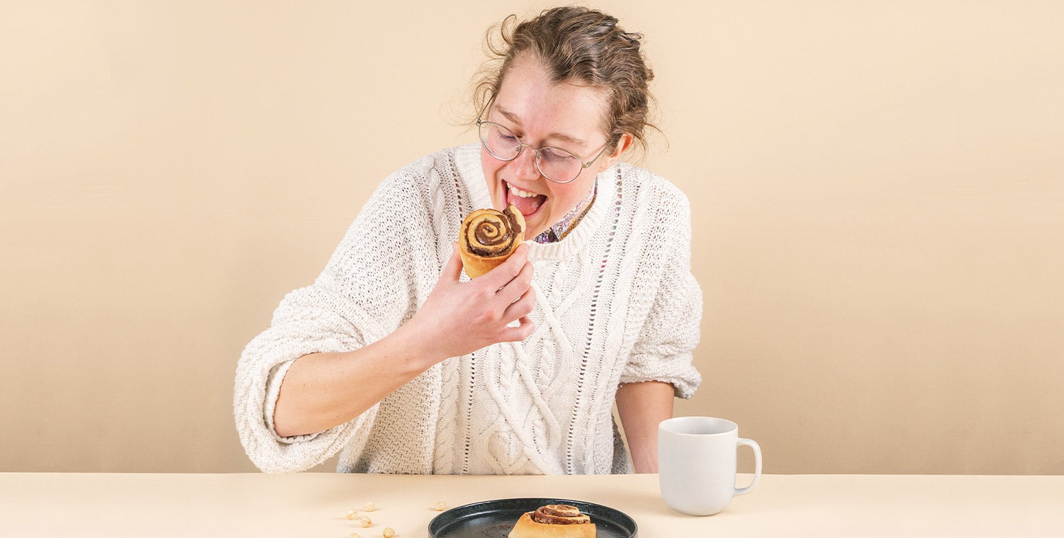 Person hält vegane Schokoschnecke und ist kurz davor davon abzubeißen