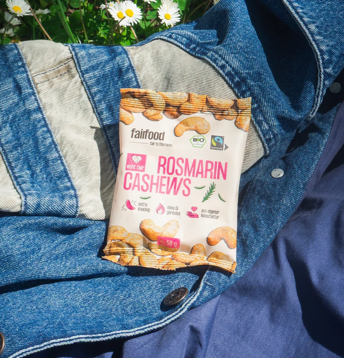 Snackbag Rosmarin Cashews auf einer Jeansjacke im Freien