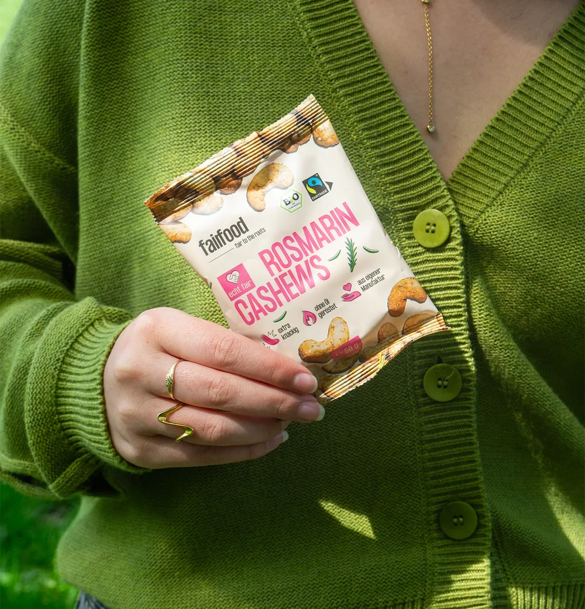 Snackbag Rosmarin Cashews gehalten von Person mit r grünem Cardigan