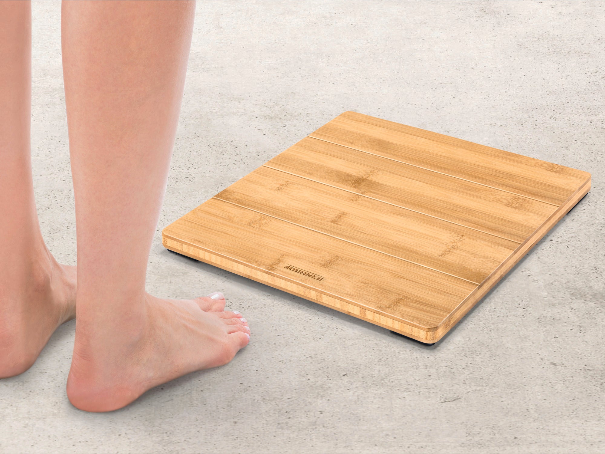 Style Sense Bamboo Magic digital bathroom scales made of natural bamboo on a floor. A person stands barefoot next to them, ready to use them. Ideal for environmentally conscious users.