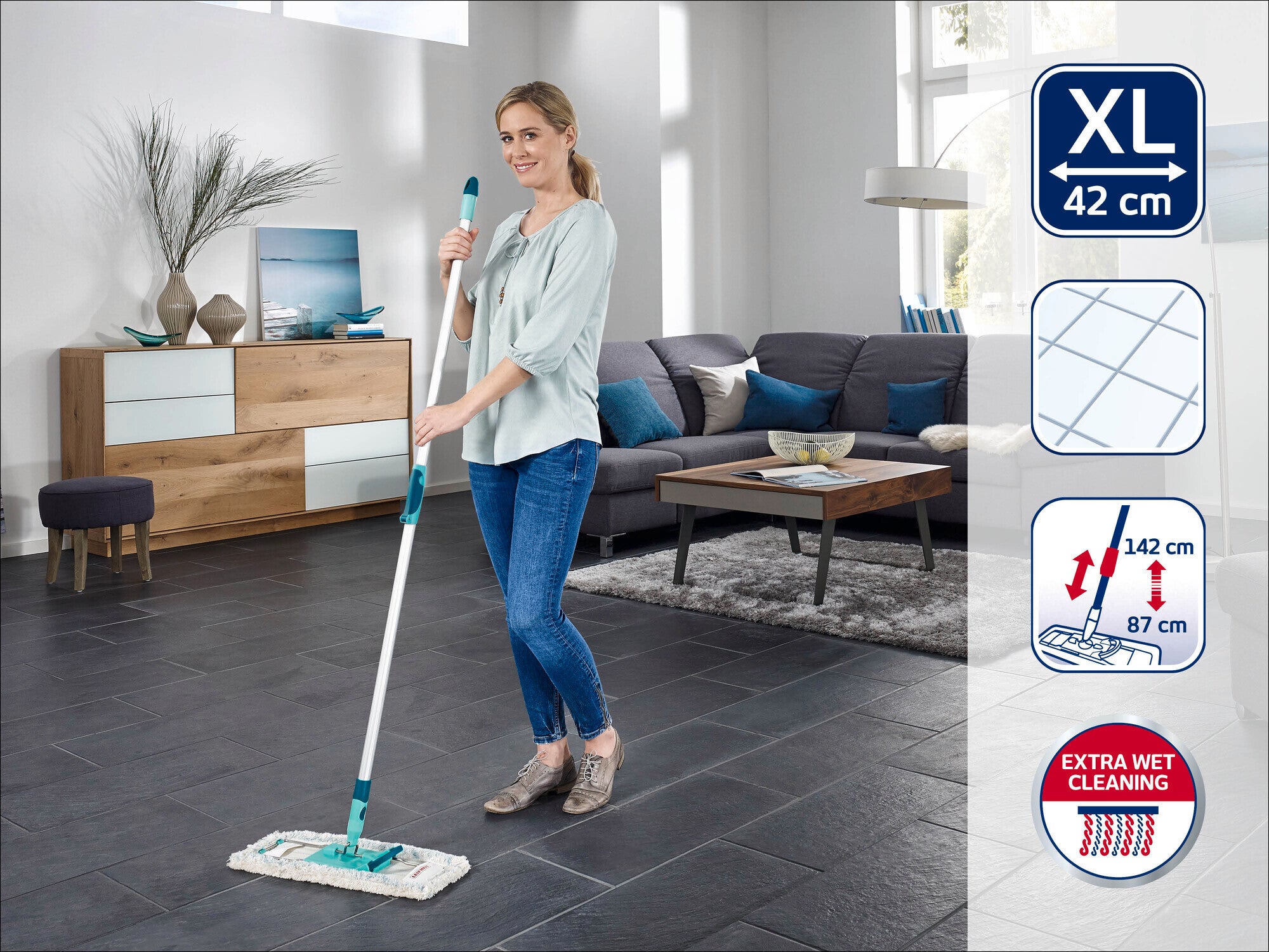 Eine Frau wischt den Boden in einem modernen Wohnzimmer mit einem Leifheit Bodenwischer XL, 42 cm. Der Wischer hat einen Teleskopstiel, der von 87 cm bis 142 cm verstellbar ist, und bietet eine extra feuchte Reinigung.
