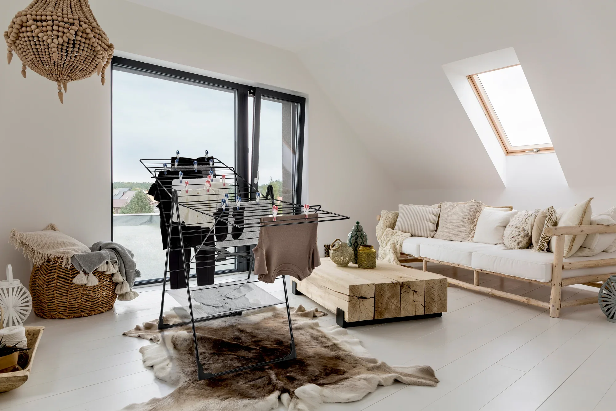 Suszarka bębnowa Classic 250 Flex w nowoczesnym salonie z dużymi oknami. Suszarka bębnowa jest załadowana ubraniami i stoi na dywanie otoczonym stylowymi meblami.