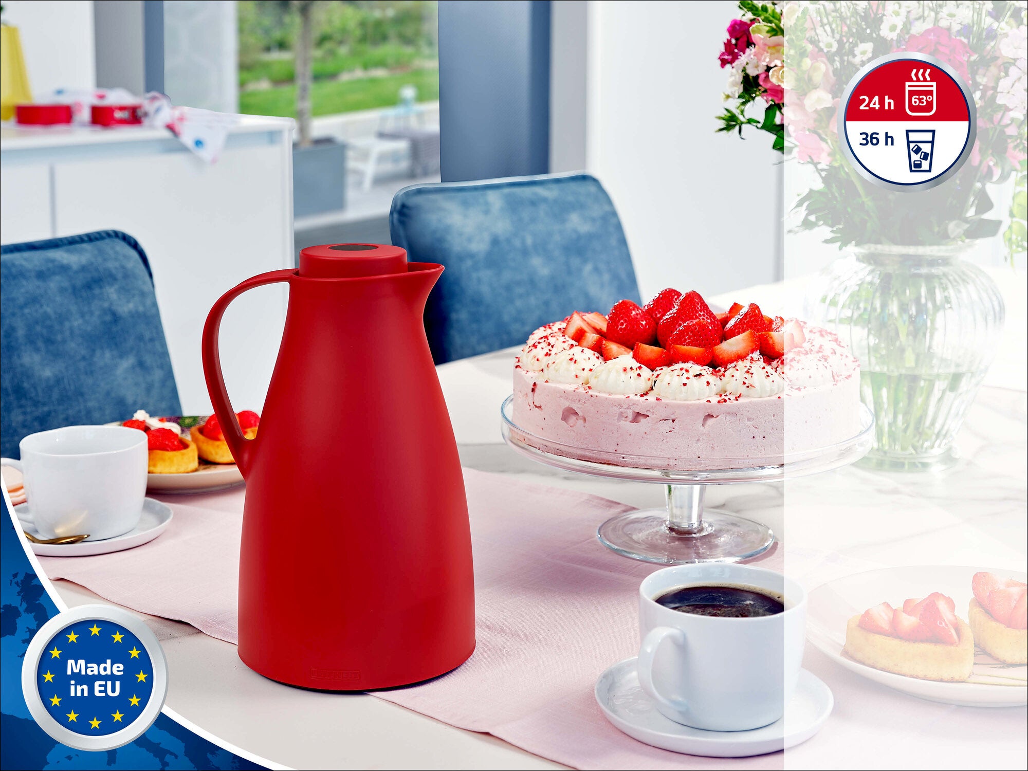 Leifheit Isolierkanne in Rot auf einem gedeckten Tisch neben Kaffee und Erdbeertorte; moderne Wohnküche im Hintergrund, mit Hinweisen auf Made in EU sowie 24- und 36-Stunden-Isolierung.