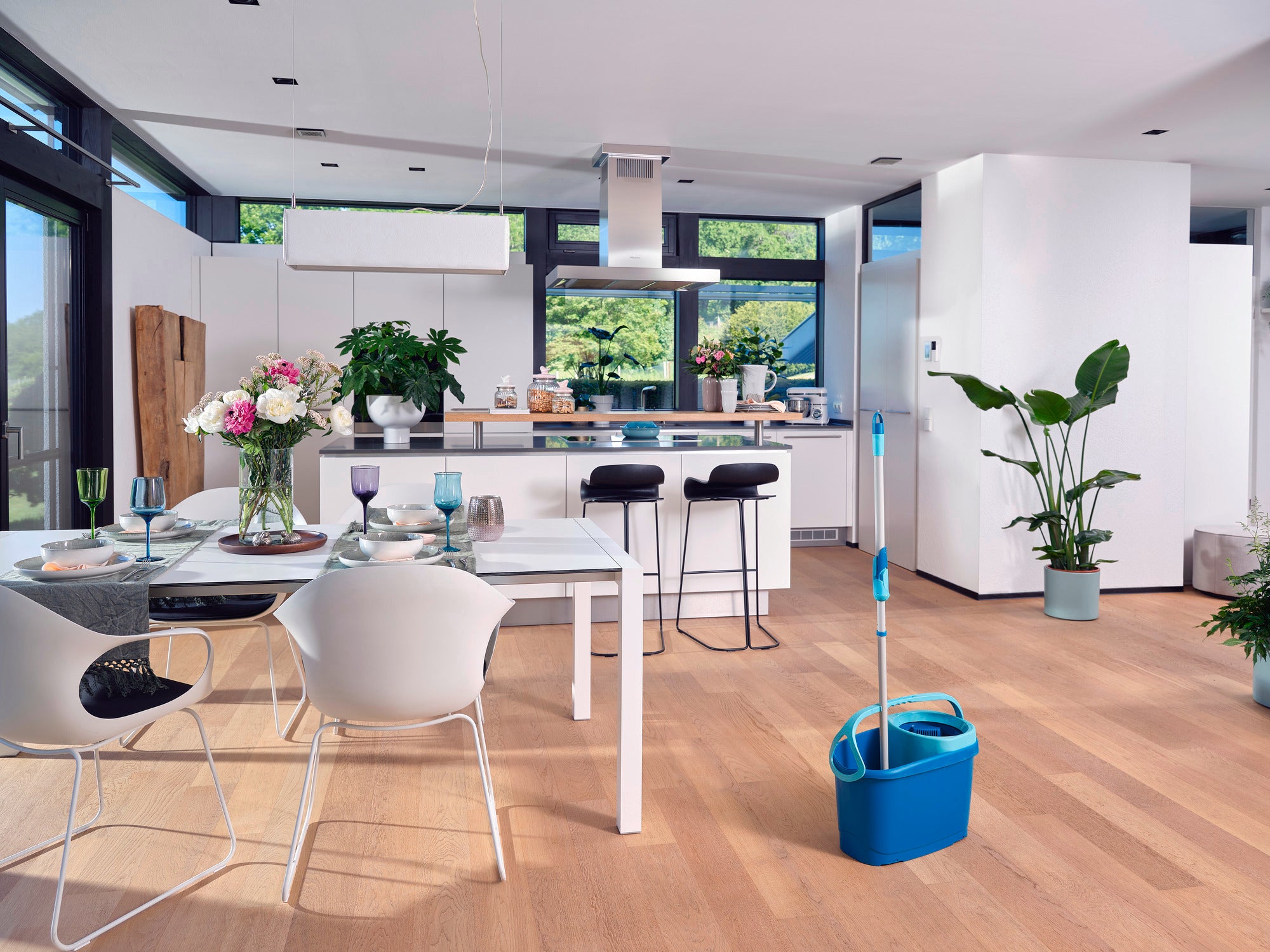 De CLEAN TWIST Set M Ergo staat klaar in een moderne keuken. De kamer is licht en stijlvol ingericht, met planten en een eettafel die uitnodigt om te blijven staan.