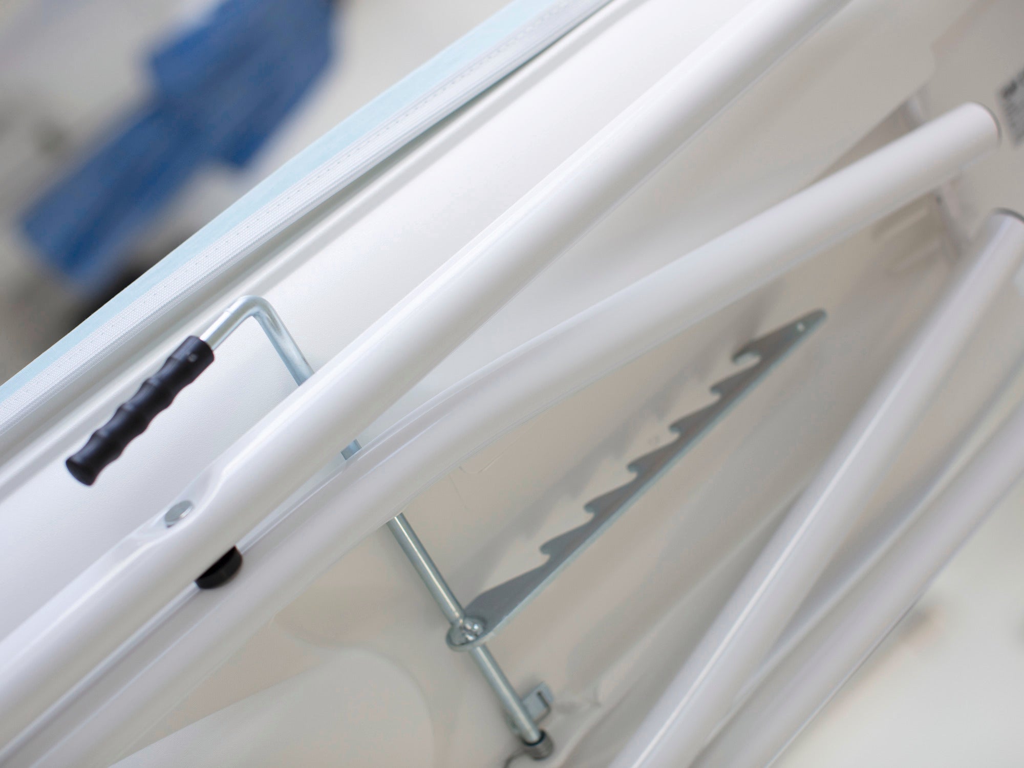 Air Active Express M strijkplank in wit, close-up van de onderkant met metalen steunen en handvat. De tafel biedt stabiliteit en functionaliteit voor efficiënt strijken.