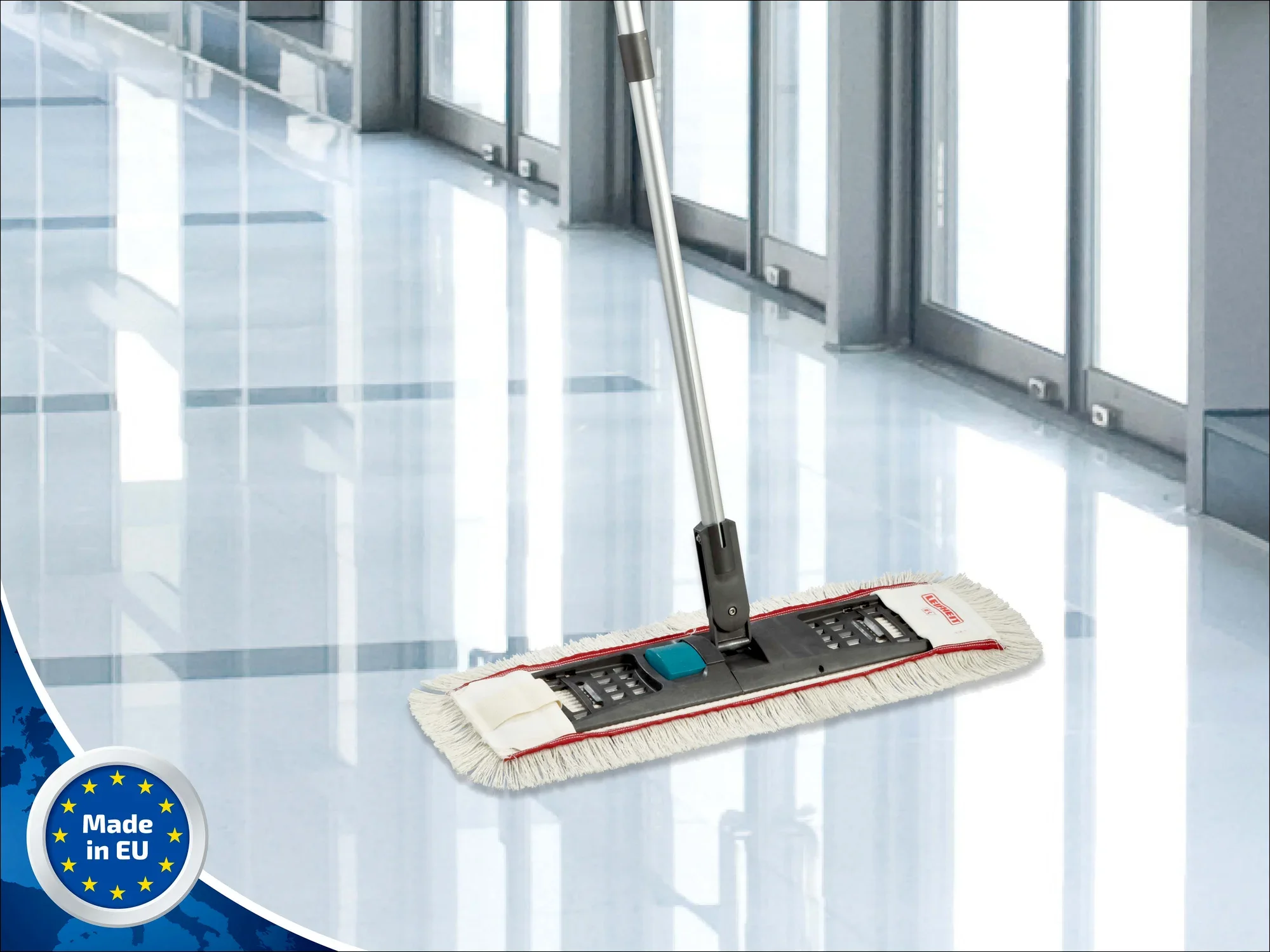 Leifheit Professional Flachwischer System auf einem glänzenden Boden in einem modernen Gebäude. Der Wischer hat einen langen Stiel und ein breites, rechteckiges Wischtuch.