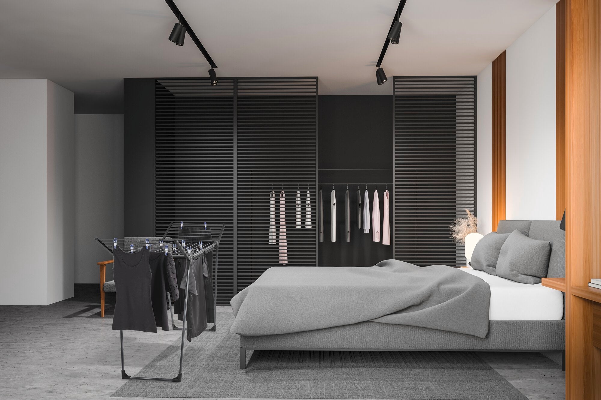 Standtrockner Pegasus 150 Solid Slim Black in einem modernen Schlafzimmer. Der Trockner steht neben einem Bett mit grauer Bettwäsche, umgeben von stilvollen, dunklen Möbeln.