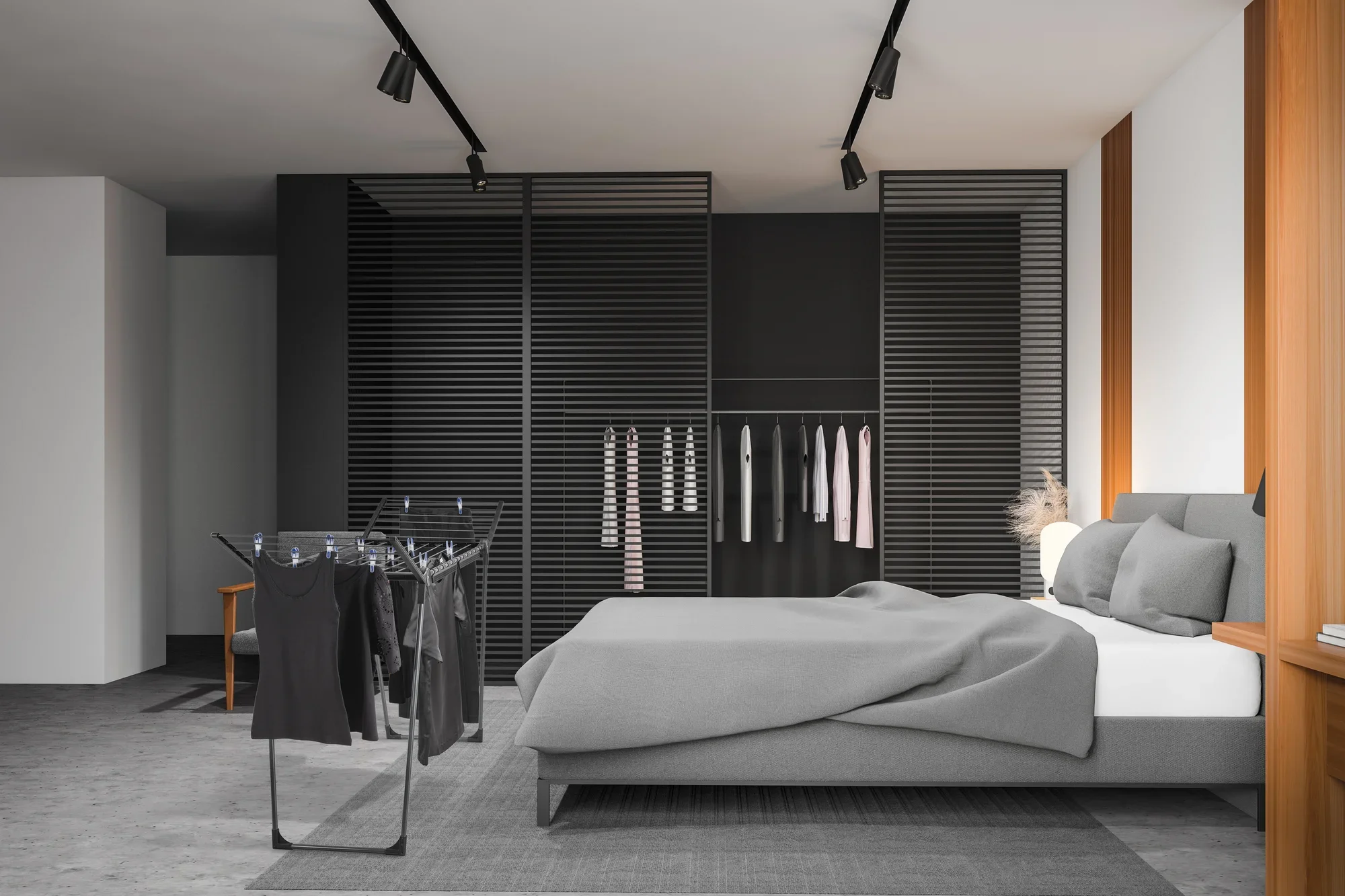 Wolnostojąca suszarka Pegasus 150 Solid Slim Black w nowoczesnej sypialni. Suszarka stoi obok łóżka z szarą pościelą, otoczona stylowymi, ciemnymi meblami.