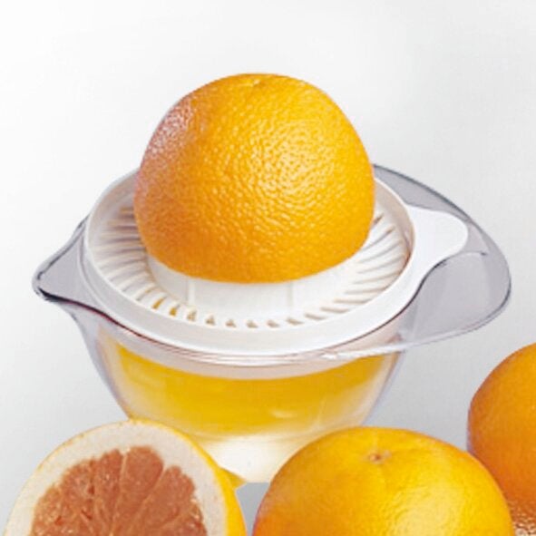 Zitruspresse mit einer halben Orange auf dem Presskegel. Die transparente Schale fängt den Saft auf. Perfekt für frische Säfte aus Orangen und anderen Zitrusfrüchten.