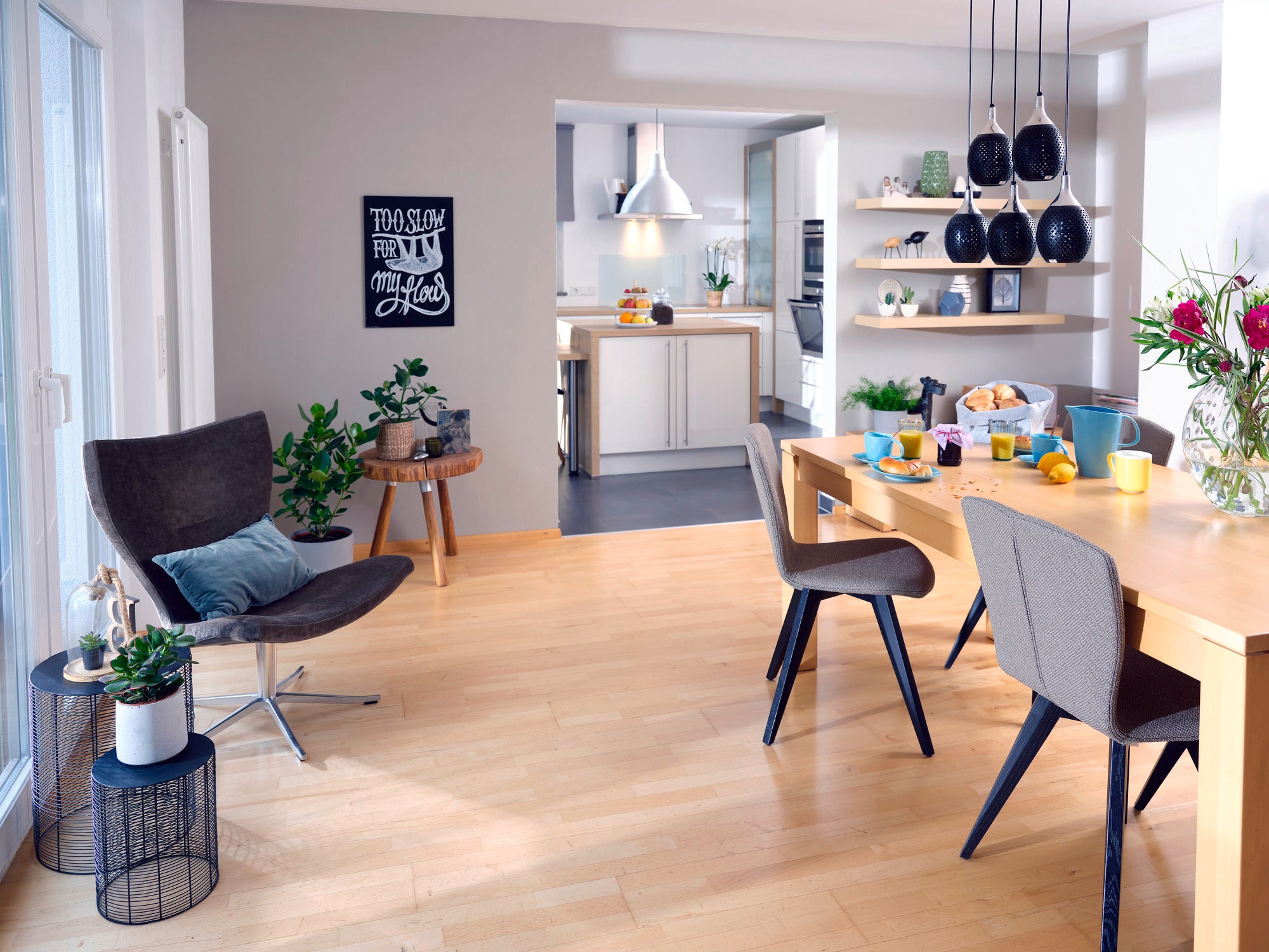 A stylishly furnished living room with a modern dining area. The Rotaro PowerVac cordless vacuum cleaner is not visible, but the surroundings are clean and tidy.