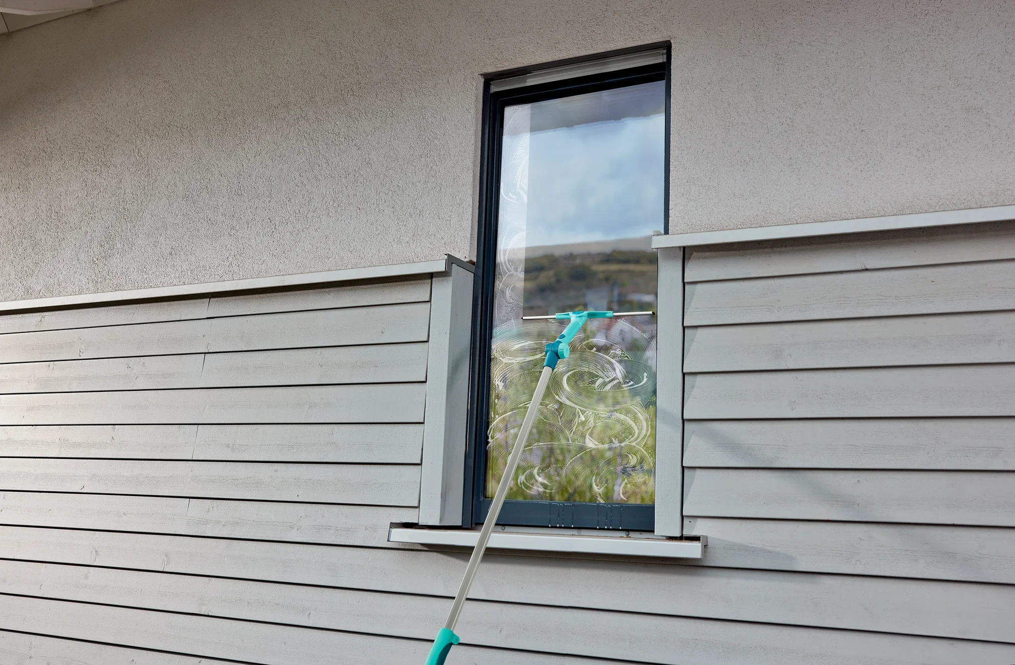 Myjka do okien używa teleskopu WindowSlider 2in1 XL ProReach do mycia wysokiego okna. Drążek teleskopowy umożliwia dotarcie do trudno dostępnych miejsc.