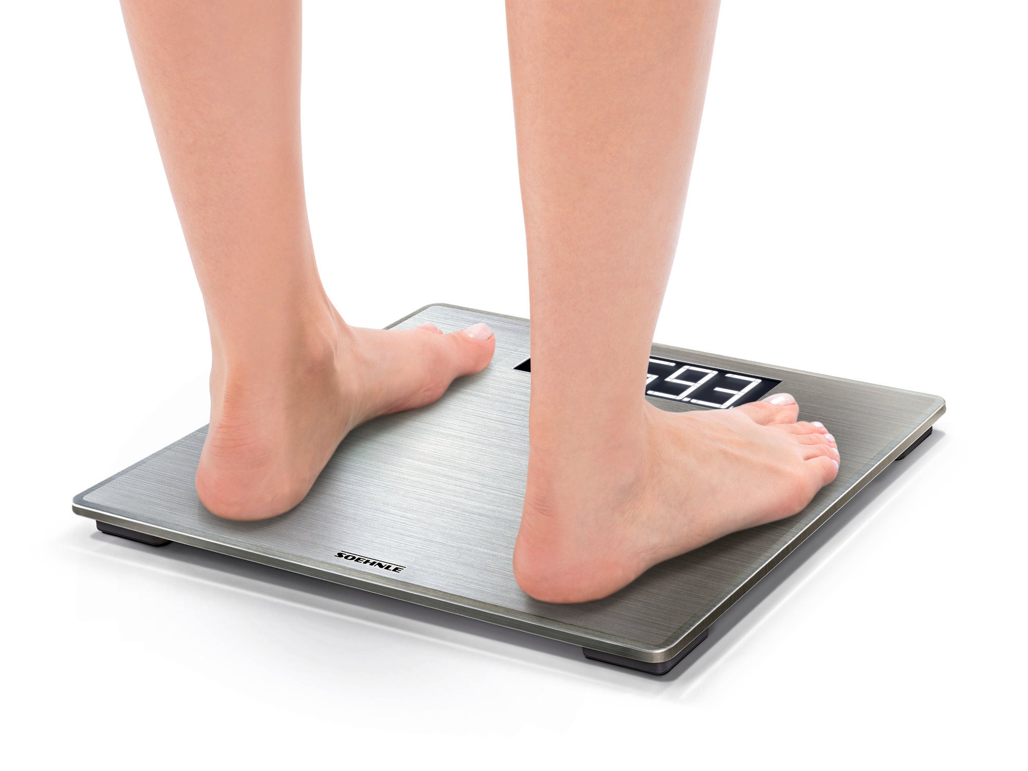 A person is standing barefoot on the Style Sense Safe 300 digital bathroom scale. The scale shows the weight on an easy-to-read display. Ideal for precise measurements.