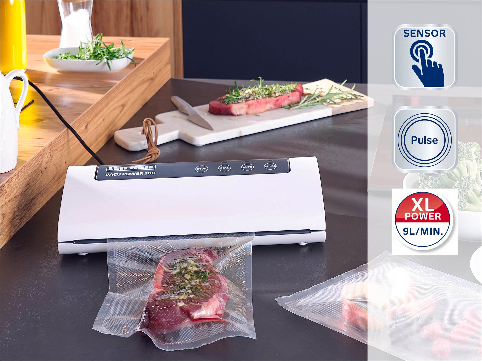 Envasadora al vacío Leifheit: una envasadora al vacío blanca sobre una encimera de cocina que envasa carne al vacío. Al fondo, hierbas frescas y carne. Se destacan la función de sensor y la función de pulso.