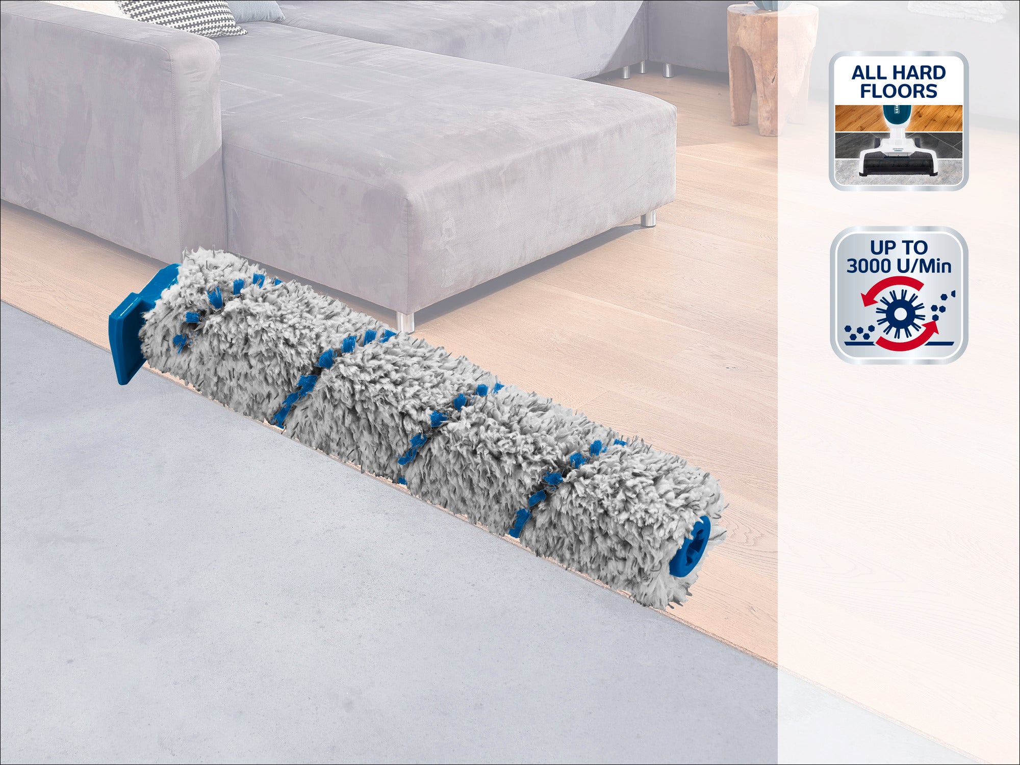 Une tête de nettoyage gris et bleu repose sur un parquet clair à côté d'un canapé gris. Convient à tous les sols durs, avec une vitesse pouvant atteindre 3000 tr/min.