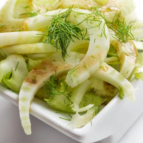 Frischer Fenchelsalat, garniert mit Dill, in einer weissen quadratischen Schale angerichtet.