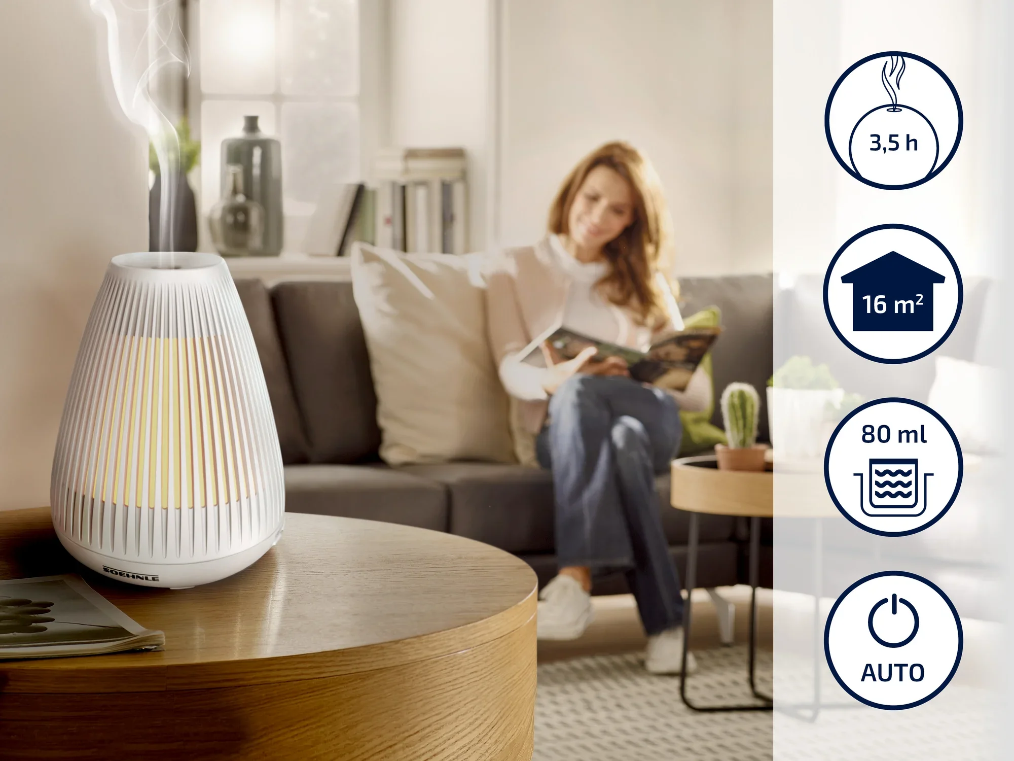 Un humidificateur Soehnle est posé sur une table en bois dans un salon confortable. À l'arrière-plan, une femme lit sur un canapé. Des symboles indiquent une autonomie de 3,5 heures, une couverture de 16 m², une capacité de 80 ml et un mode automatique.
