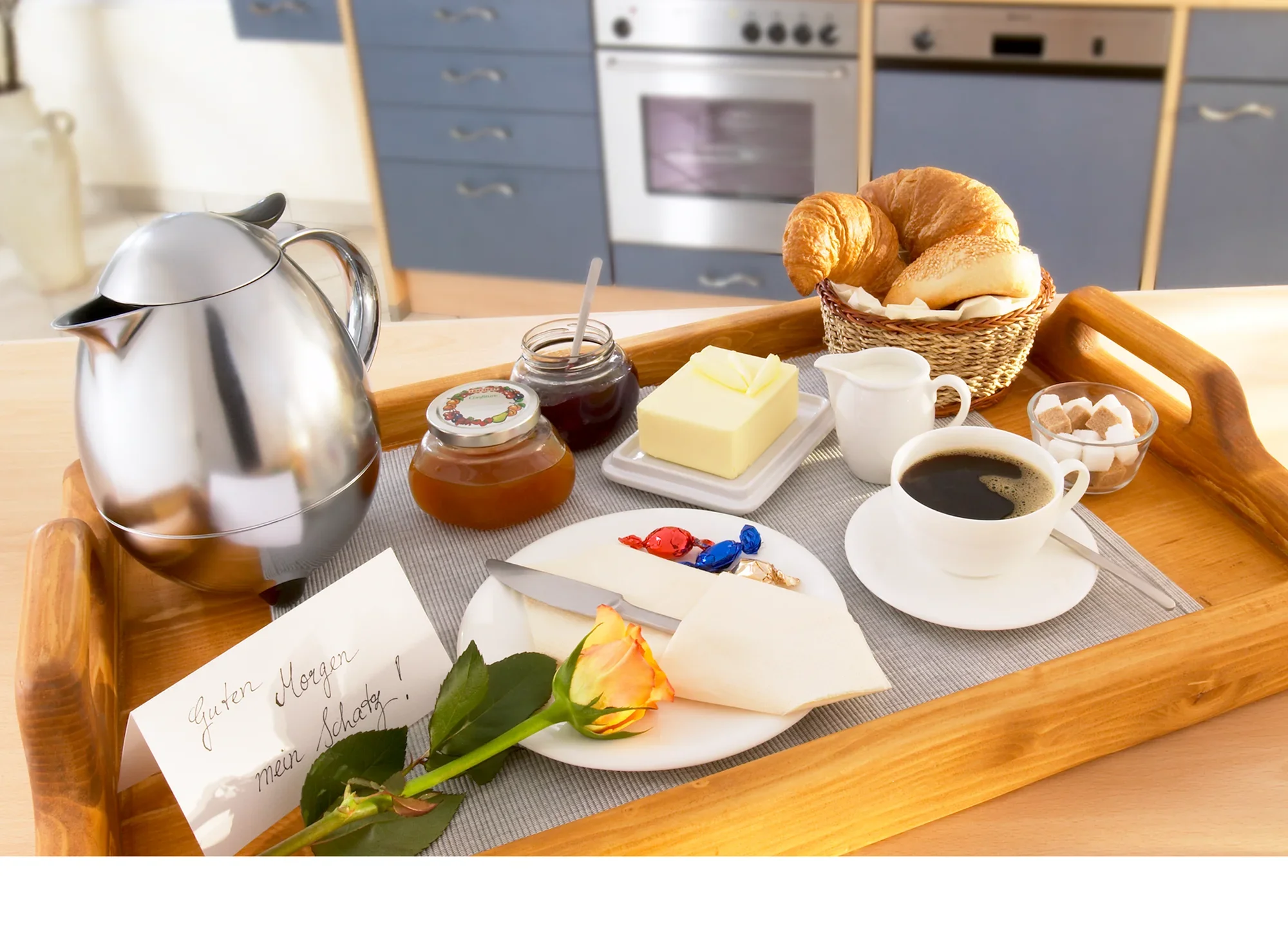 Ein Frühstückstablett mit einer Isolierkanne Columbus 1L in Chrom. Daneben befinden sich Kaffee, Croissants, Marmelade, Butter, Zuckerwürfel und eine Rose.