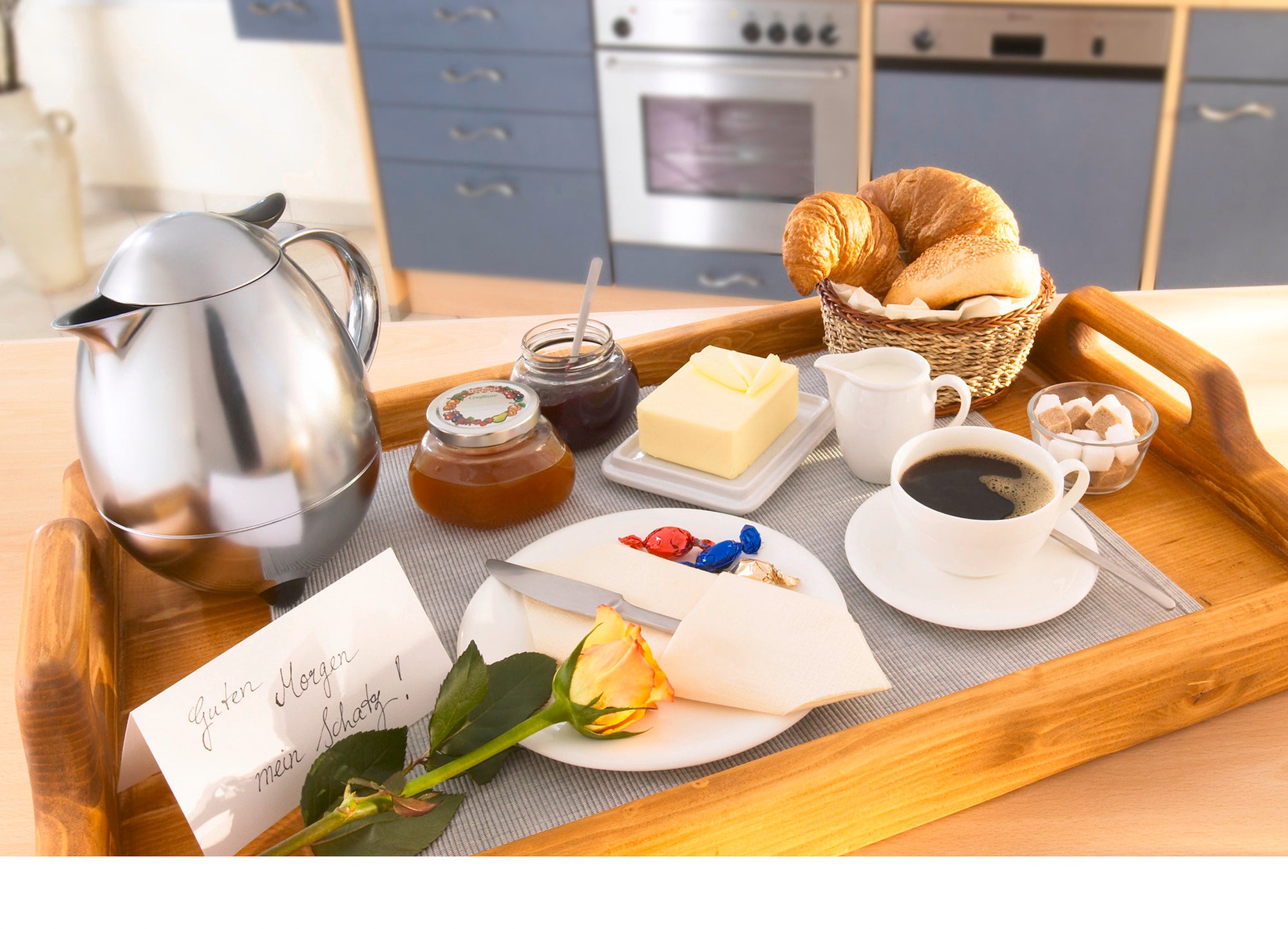 Ein Frühstückstablett mit einer Isolierkanne Columbus 1L in Chrom. Daneben befinden sich Kaffee, Croissants, Marmelade, Butter, Zuckerwürfel und eine Rose.