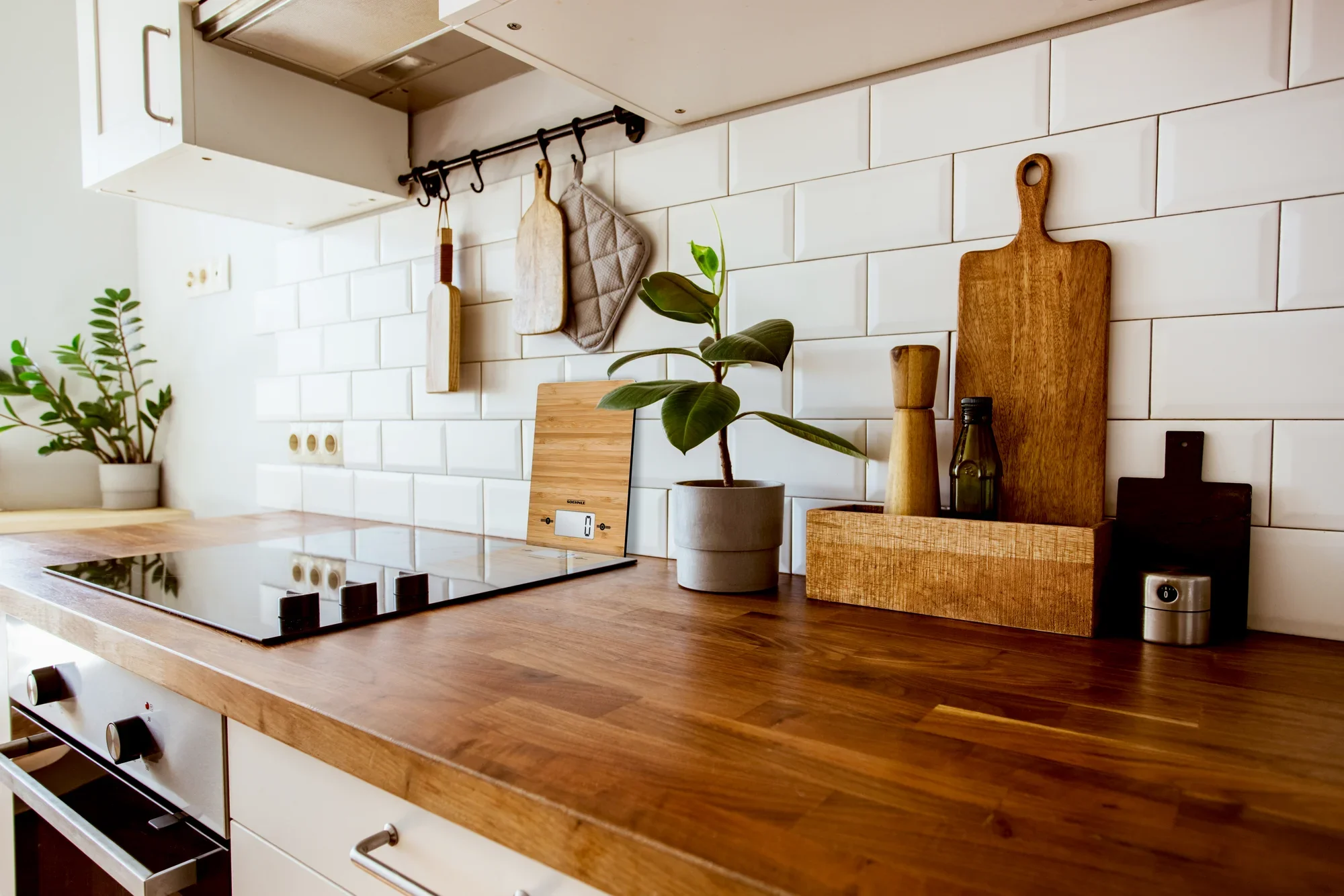 Digitale Küchenwaage Bamboo auf einer stilvollen Küchenarbeitsplatte aus Holz, umgeben von Schneidebrettern, Pflanzen und Küchenutensilien. Ideal für moderne Küchen.