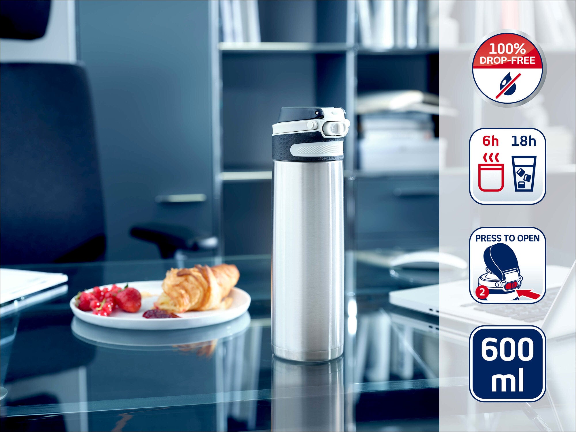 Leifheit Isolierbecher 600 ml aus Edelstahl steht geöffnet auf einem Glastisch im Büro; daneben Teller mit Croissant und Beeren. Seitliche Symbole zeigen auslaufsicheres Design sowie 6 h warm und 18 h kalt.