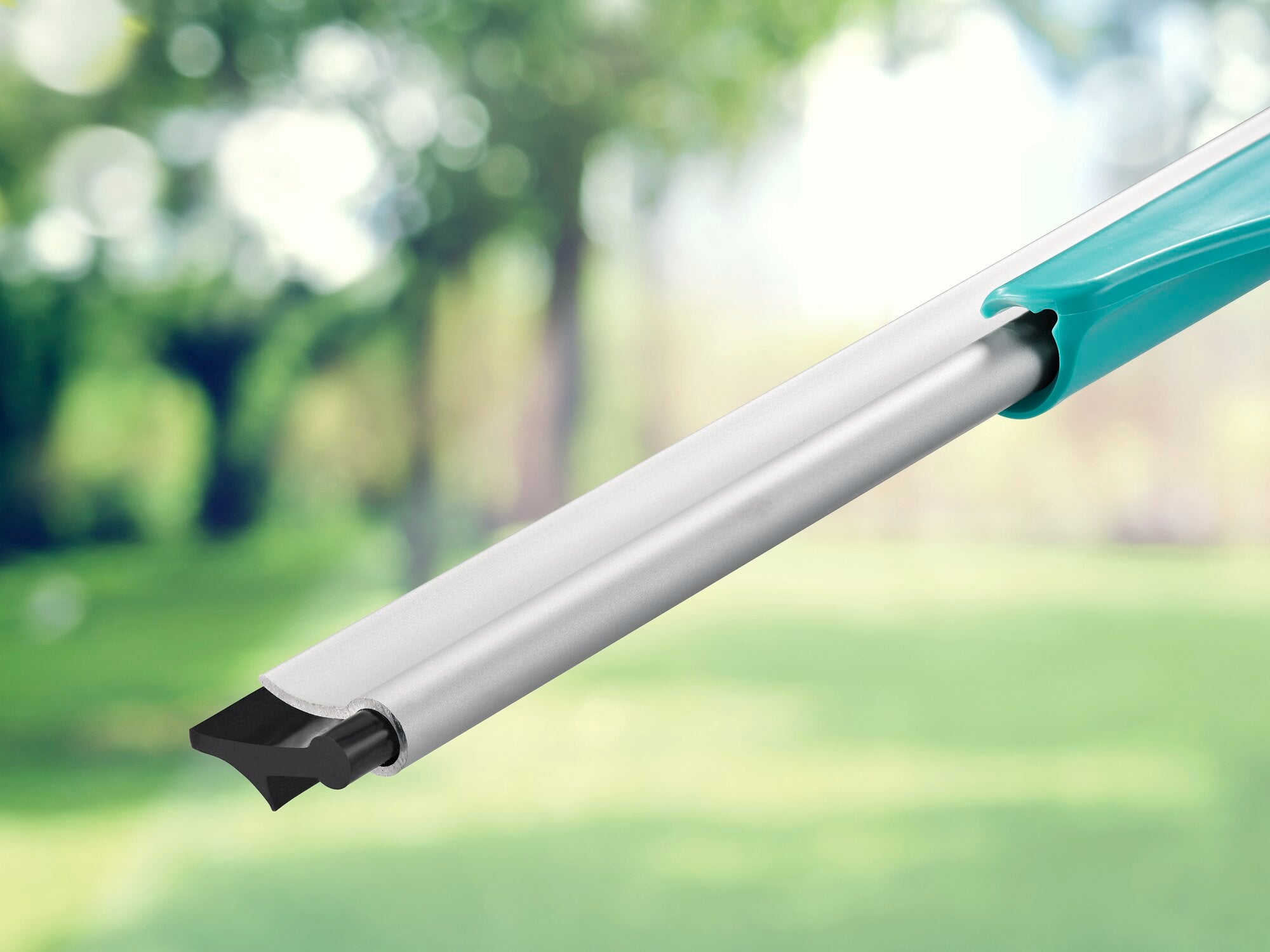 Ein Fensterreiniger mit ausziehbarem Griff, der als "Window Slider 2in1 XL ProReach" bekannt ist, wird in einem grünen Gartenhintergrund gezeigt. Ideal für schwer erreichbare Stellen.