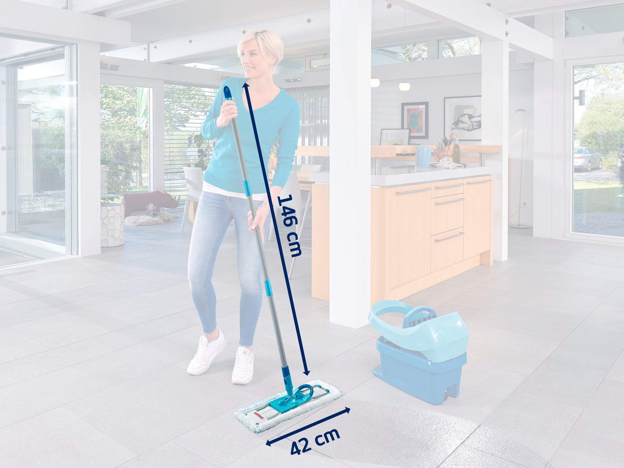 Kobieta myje podłogę w nowoczesnej kuchni mopem Leifheit. Mop ma 146 cm długości i 42 cm szerokości. Obok stoi pasujące wiadro.