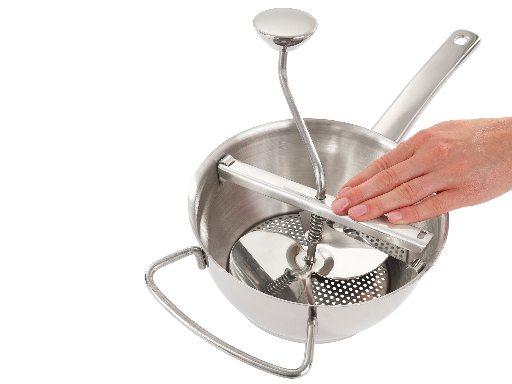 Food mill in use. One hand turns the handle of the stainless steel food mill to strain food. Ideal for making purées and soups.