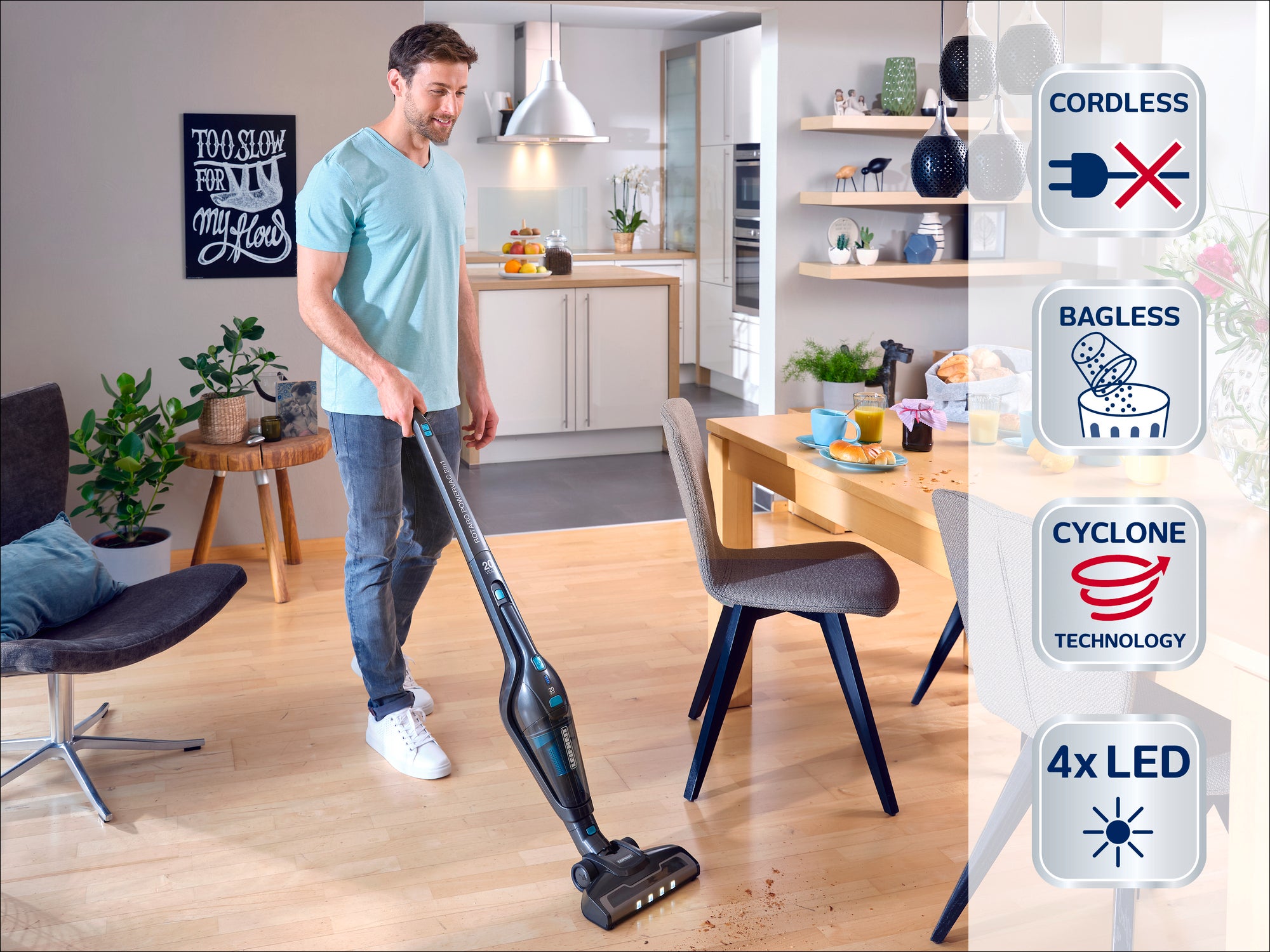 Un homme utilise un aspirateur sans fil et sans sac avec technologie cyclonique dans un salon moderne. L'aspirateur est équipé de 4 LED pour une meilleure visibilité.