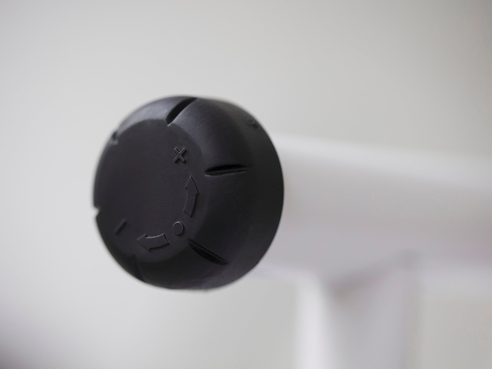 Nahaufnahme eines schwarzen Drehknopfes am Bügeltisch Air Active Express M. Der Knopf ist auf einem weißen Hintergrund zu sehen und zeigt Details der Funktionalität.