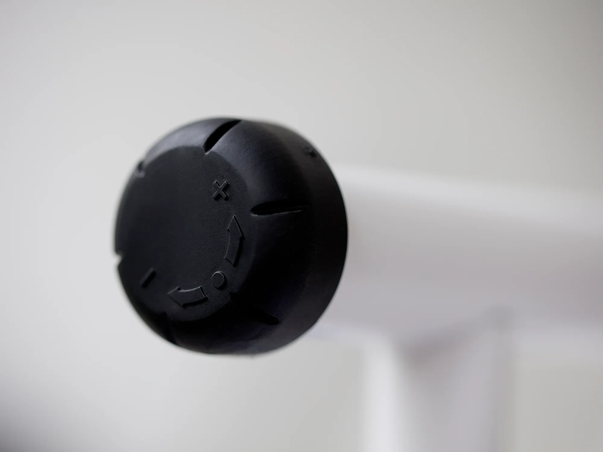 Gros plan sur un bouton rotatif noir de la table à repasser Air Active Express M. Le bouton est visible sur un fond blanc et montre les détails de sa fonctionnalité.