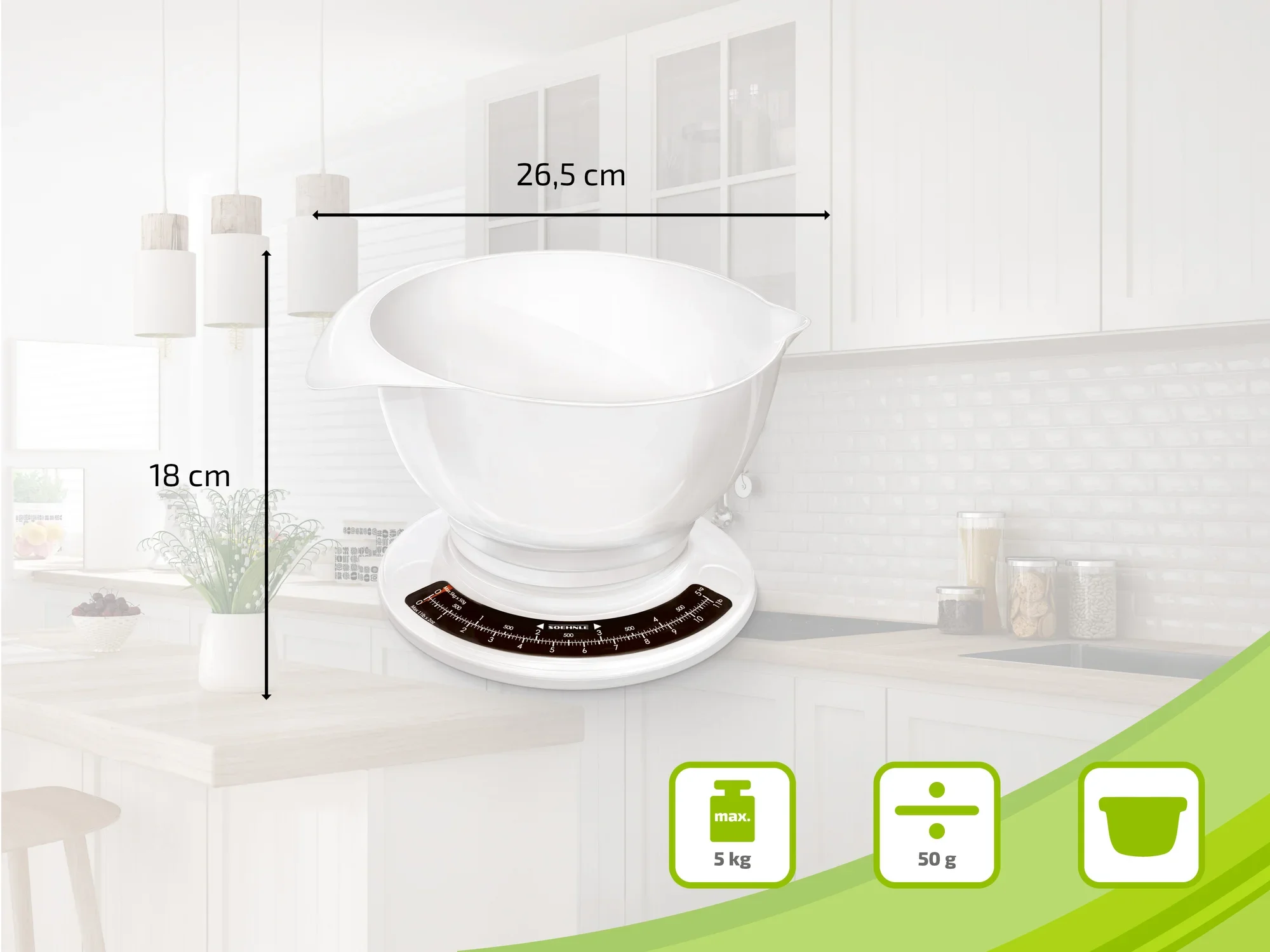 Waga kuchenna z białą miską, o szerokości 26,5 cm i wysokości 18 cm, na blacie kuchennym. Waga ma nośność 5 kg i dokładność 50 g.