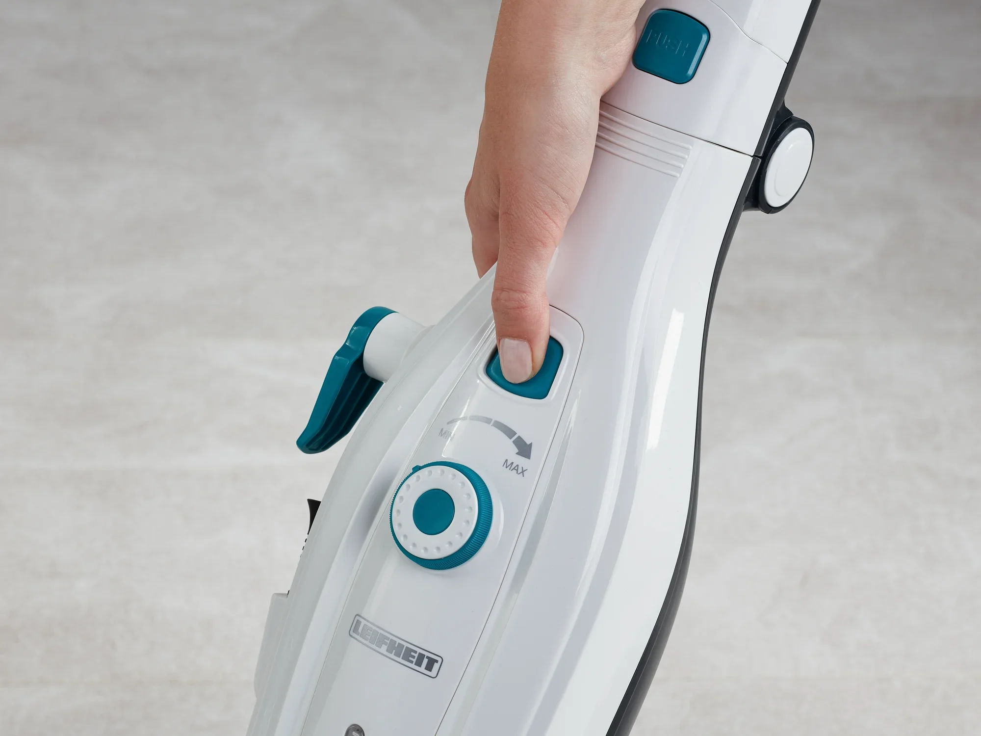 Eine Hand bedient den Dampfreiniger Clean Tenso. Der Fokus liegt auf den Bedienelementen, die eine einfache Steuerung ermöglichen. Ideal für eine gründliche Reinigung.