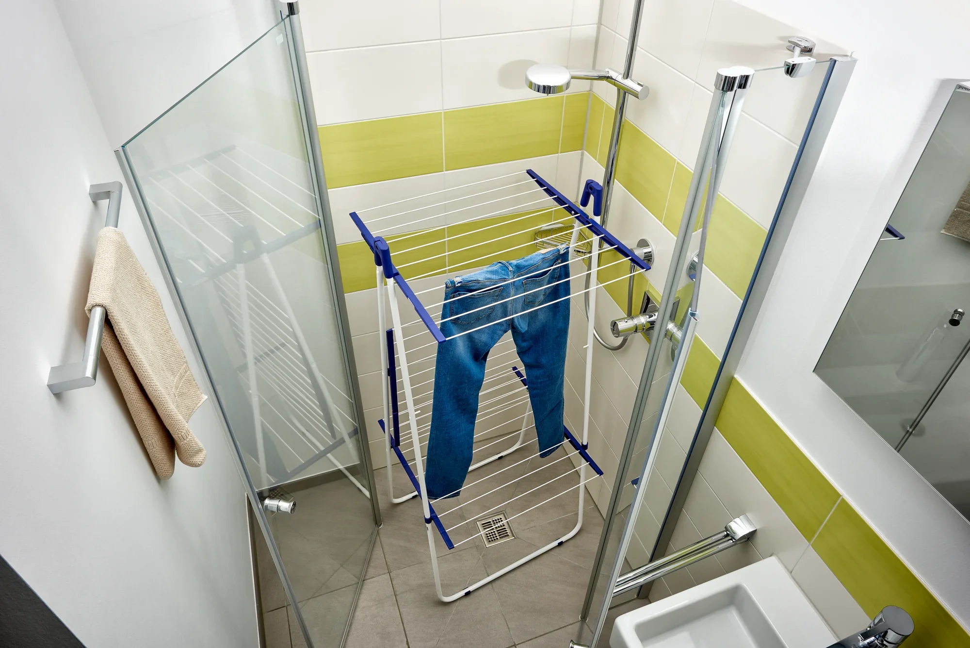 Een Pegasus Tower 190 torendroger staat in een moderne, lichtgekleurde douche. Het is uitgerust met een spijkerbroek en biedt een ruimtebesparende oplossing voor het drogen van kleding.