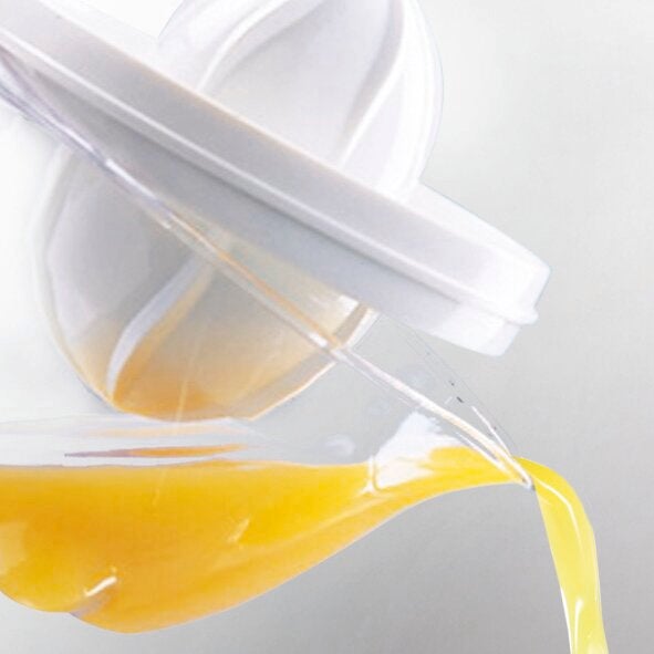 Zitruspresse im Einsatz: Frischer Orangensaft fließt aus einer modernen, weißen Zitruspresse. Die Presse zeigt ein elegantes Design und ist ideal für den täglichen Gebrauch.