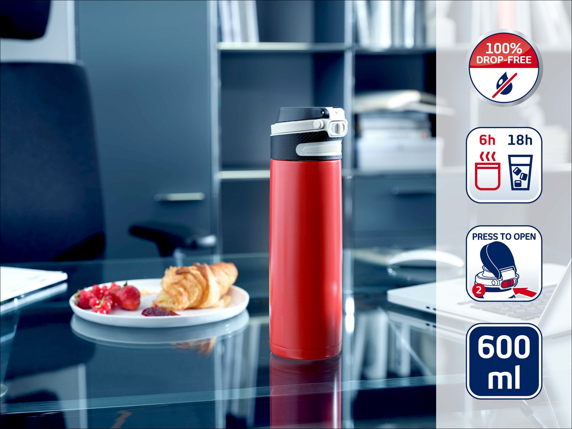 Leifheit Isolierbecher 600 ml in Rot mit grauem Deckel steht auf einem Glastisch im Büro; daneben liegen Croissant und Beeren. Seitlich zeigen Symbole tropffrei, 6 h heiß, 18 h kalt und Press-to-open.