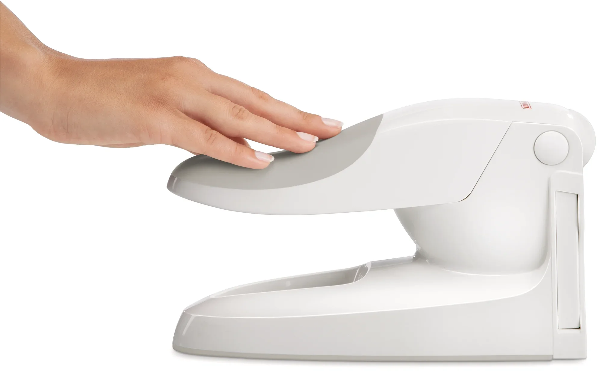 De hendel van een witte frietsnijder wordt met één hand ingedrukt. Het toestel is compact en ergonomisch ontworpen, ideaal om gemakkelijk friet te bereiden.