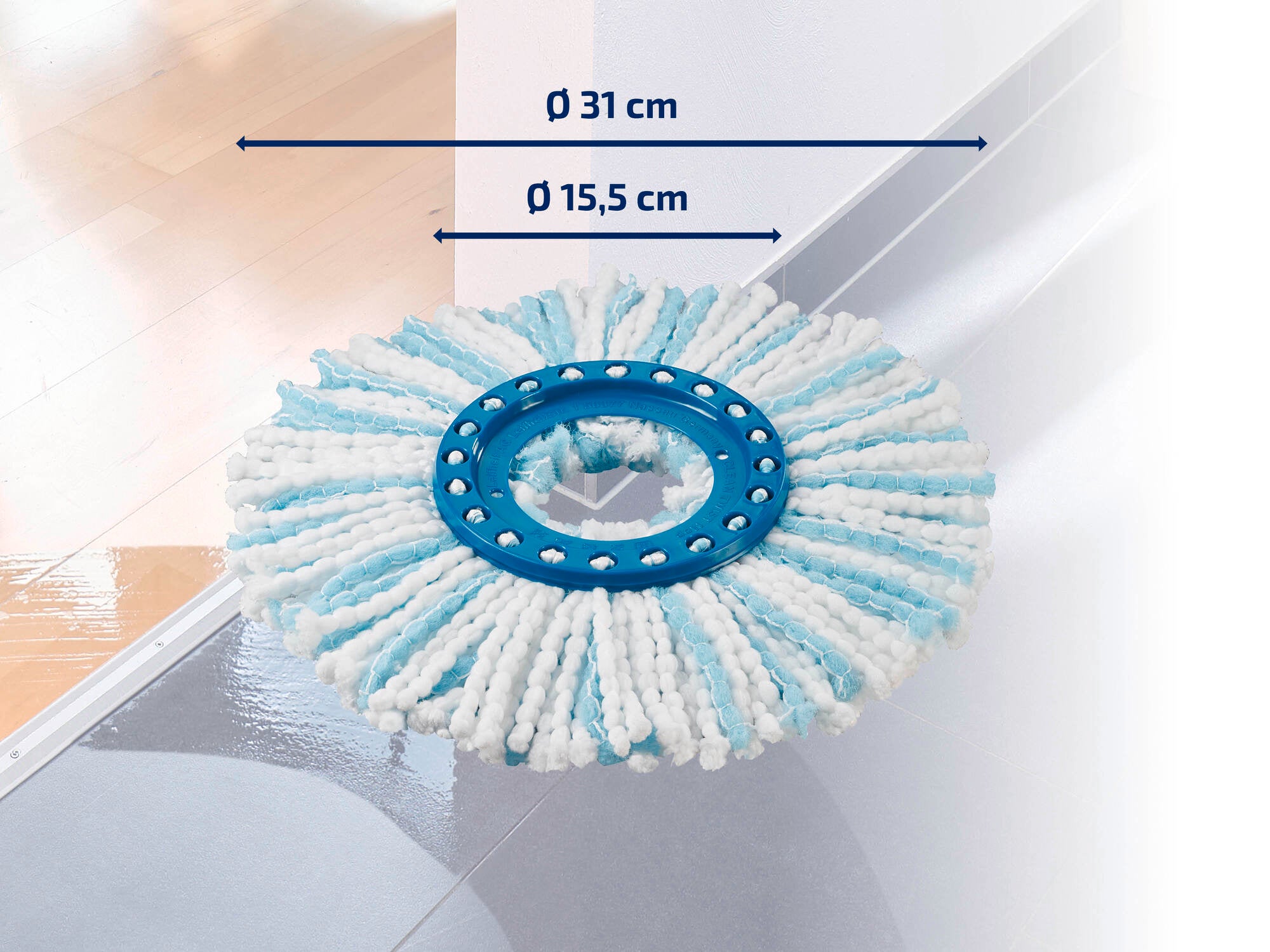Ein runder Wischmop-Aufsatz mit einem Durchmesser von 31 cm und einem inneren Ring von 15,5 cm liegt auf einem glänzenden Boden. Der Aufsatz hat weiße und blaue Streifen.