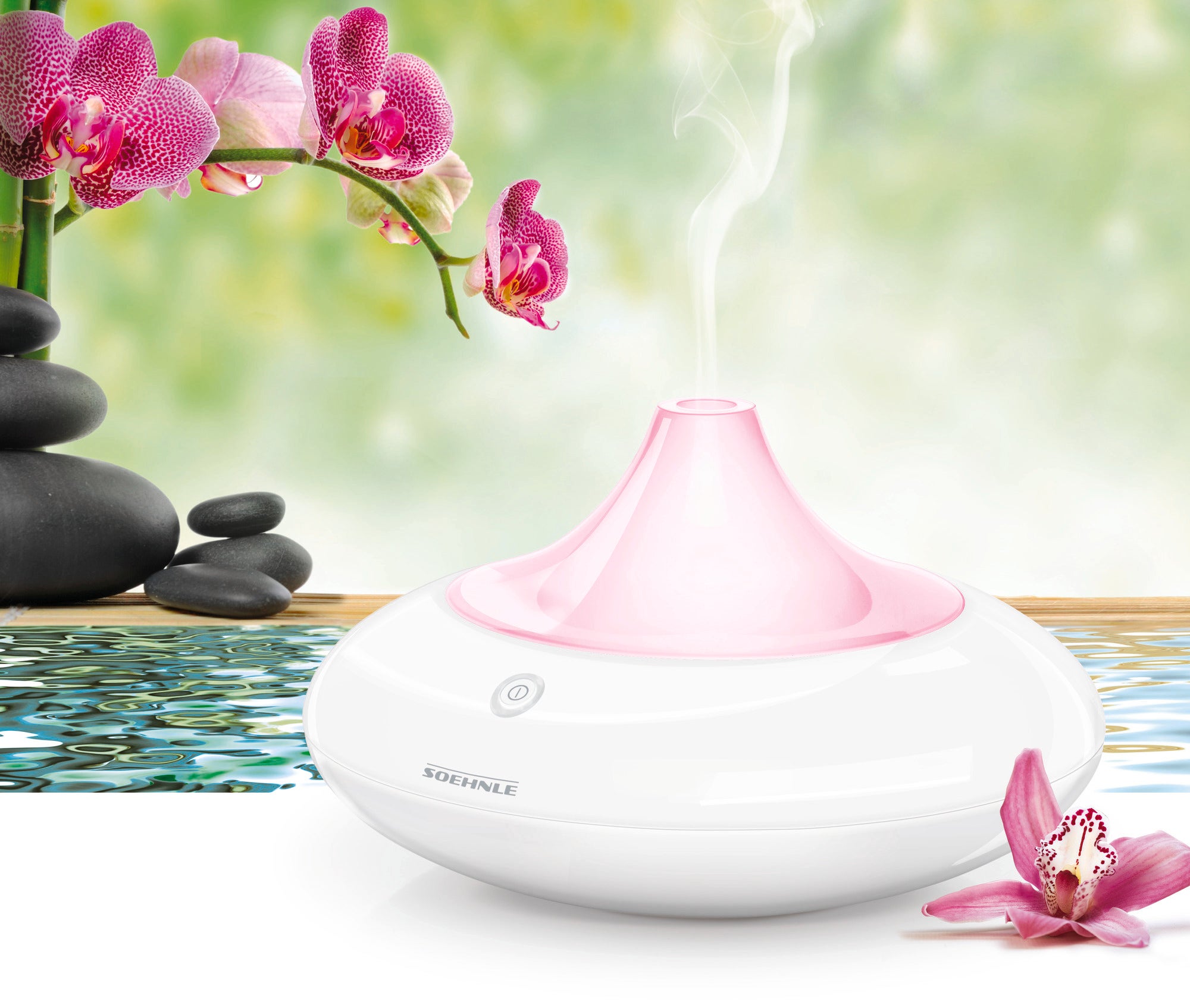 Designerski dyfuzor zapachowy Ravenna stoi na stoliku otoczonym różowymi kwiatami orchidei. Dyfuzor emituje delikatną parę, która tworzy uspokajającą atmosferę.