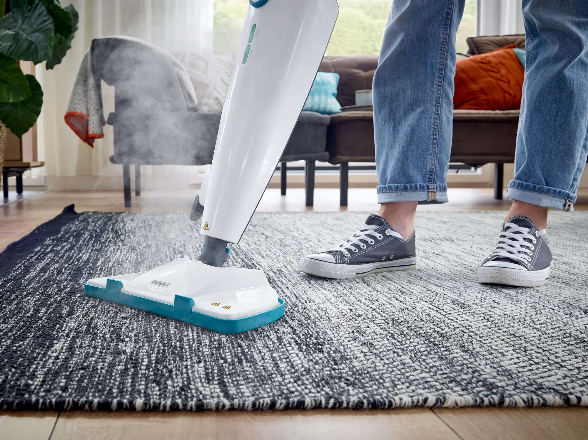 Dampfreiniger CleanTenso Power in Aktion auf einem Teppich. Eine Person bedient das Gerät, während Dampf austritt, um den Boden gründlich zu reinigen.